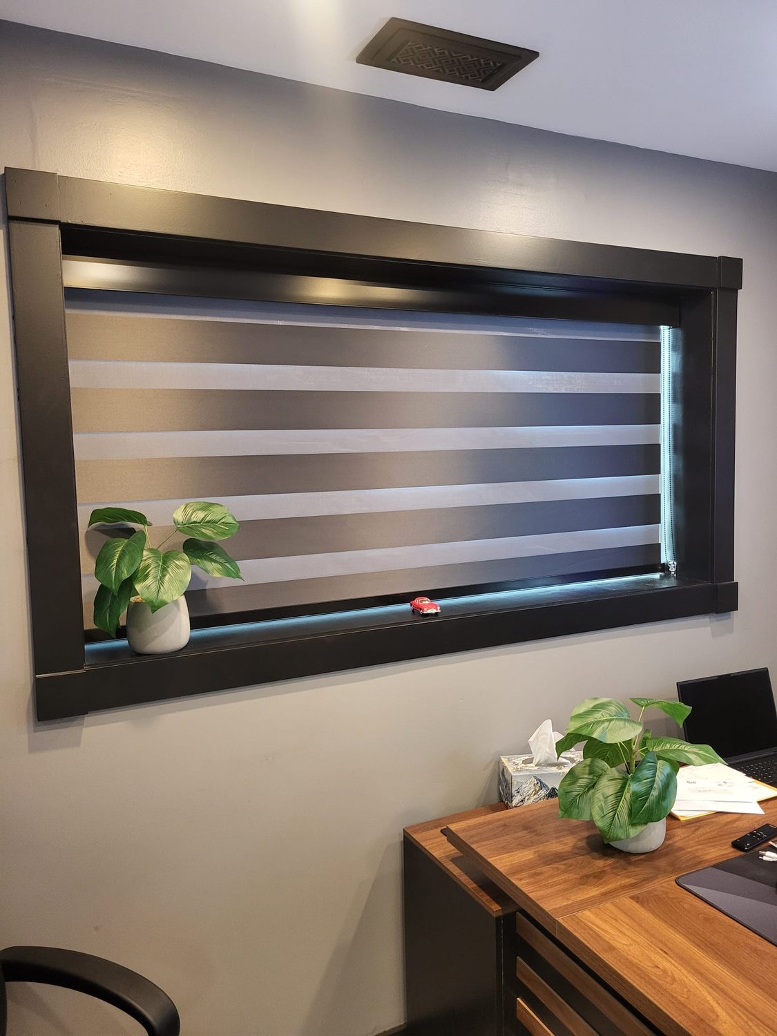 Motorized zebra blinds on a wide home-office window